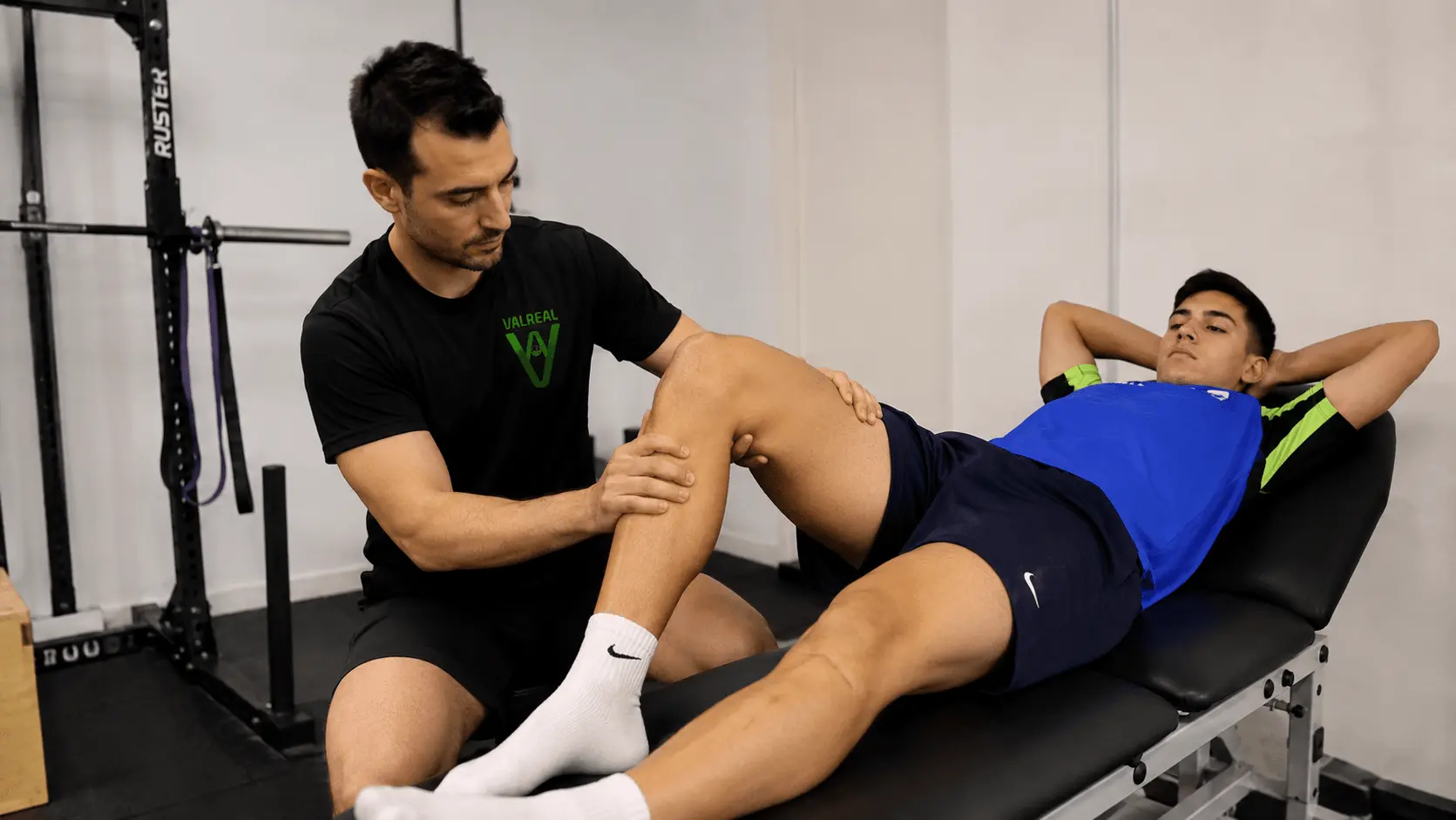 Profesional valorando la rodilla de un deportista durante una sesión de readaptación